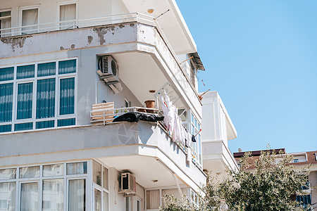 白色破旧破败的住宅楼 阳台上晾着衣服 简单的人生活 带有旧空调系统的破旧住宅区图片