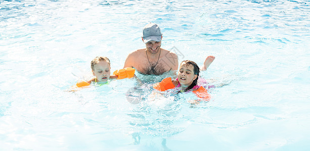 快乐的家庭在海洋热带度假胜地的蓝水游泳池里玩耍 暑假的概念 笑声母亲婴儿水池父亲棕榈女士活动乐趣旅行妈妈图片