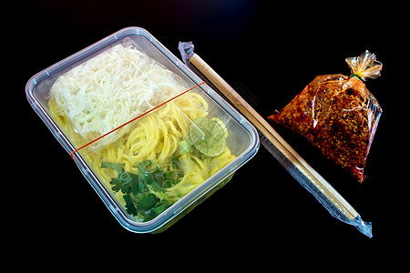 带酱汁的意大利面条 用塑料包装将食物带回家筷子红色美食盒子托盘图片