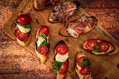 在木板上排列各种不同的小吃或意式烤面包 地中海美食概念蔬菜火腿早餐营养饮食食物点心起动机午餐面包图片