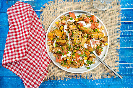 乡村餐桌上的碗里放着美味的土豆 鹰嘴豆 番茄和蘑菇沙拉 配欧芹和蒜泥蛋黄酱 健康 自制的纯素食品 复制空间图片