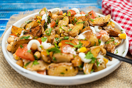 美味的马铃薯 鸡皮豆 番茄和蘑菇沙拉 在木制桌子上配有煎饼和椰菜 健康 自制 素食食品图片