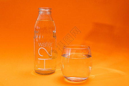装有橙色和浅橙色梯度底部净水的瓶子和玻璃桶环境流动矿物液体食物生活飞溅茶点苏打蓝色图片