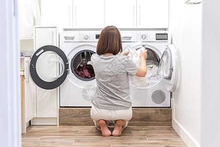在现代公用事业厅洗涤洗衣机中装上妇女脏衣服用于洗洗家政地面卫生成人家务器具垫圈女士工作房子图片