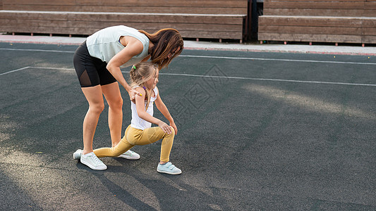 白人妇女和她的女儿一起去户外运动 一个女学生和她的妈妈在体育场里跑来跑去女性公园训练孩子们身体健身房孩子闲暇护理母亲图片