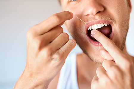 在你的牙科卫生游戏上 一个年轻人在家牙缝牙膏的近镜头图片