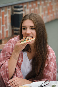 穿白上衣在餐厅吃披萨的怪味黑发女孩微笑乐趣成人咖啡店快乐食物女士小吃幸福享受图片