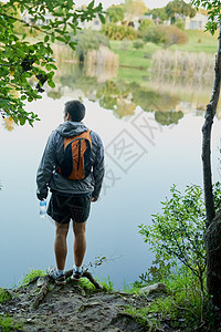 这里的景象是不真实的 一位年轻男性运动员在森林里漫步时 在湖边观赏湖景的回视镜头图片