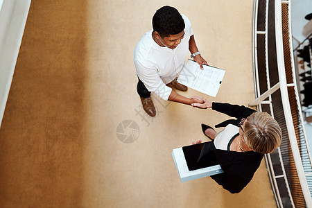齐心协力 共创佳绩 两个商务人士在办公室握手的高角度镜头背景图片