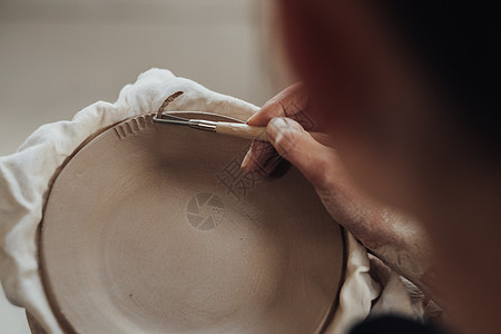 工作中的女陶艺家特写 女人在粘土板上创造图案 艺术作品在进行中作坊黏土围裙女士生意女性艺术家商业闲暇手工图片