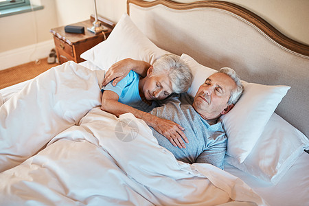 他仍然抱着我 直到我睡着 一对深情的老年夫妇在疗养院的床上睡着时互相依偎的镜头图片