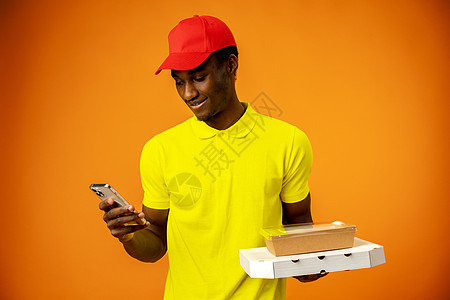 身穿便服 手持智能手机纸板包裹的非洲送货员图片