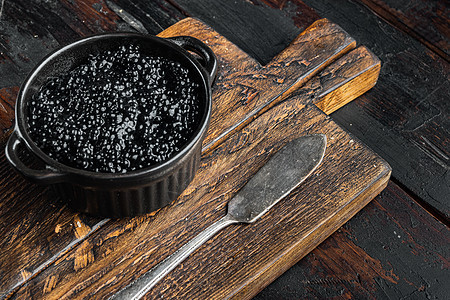 黑色鱼子酱 在旧黑木桌背景上深色美味胡索白鲸木质玻璃桌子海鲜背景图片