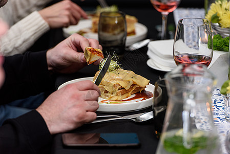 男人在餐馆里吃法兰西辛哈 葡萄牙传统三明治 国家烹饪概念火腿蔬菜手套食物美食文化午餐餐厅服务面包图片