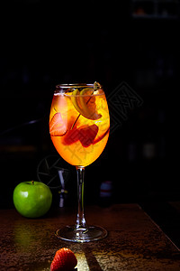 配草莓片和苹果的红鸡尾酒玻璃水果酒吧食物餐厅饮料桌子果汁橙子液体图片