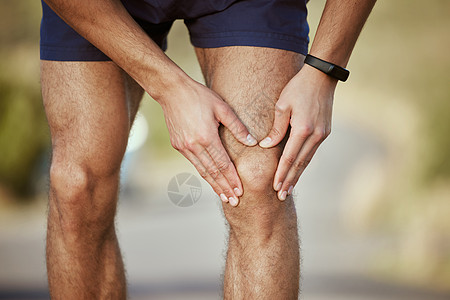 近距离拍到一个不知名的男人在户外运动时 膝盖痛得要命的紧身镜头图片