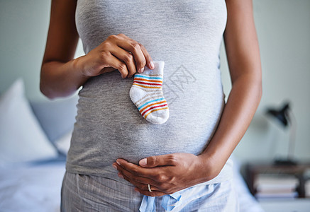 小脚需要小袜子 一个孕妇在肚子前 抱着婴儿袜子的被割伤的镜头图片