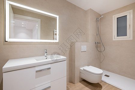 现代浴室 配有米砖 淋浴 厕所和带照明的长方形大镜子图片