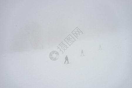 在薄雾的白天 在斜坡上乘滑雪机车站运动员白色运动滑雪者松树道路森林索道爬坡图片