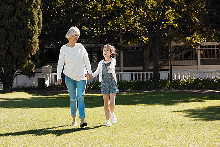 一起享受多么美好的一天 一个小女孩和她的祖母在公园里散步的镜头图片