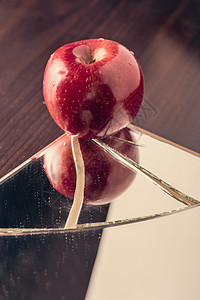 破碎的镜子上的红苹果反射玻璃白色裂缝碰撞红色危险粉碎食物损害图片