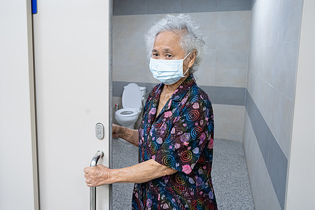 亚洲老年老年妇女病人在护理医院病房手工打开厕所浴室 健康强大的医疗理念房子入口钥匙出口金属框架建筑学安全退休木头图片
