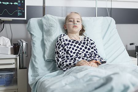 孤单的年青患病女孩病人在康复病房休息时躺在儿科门诊床上图片