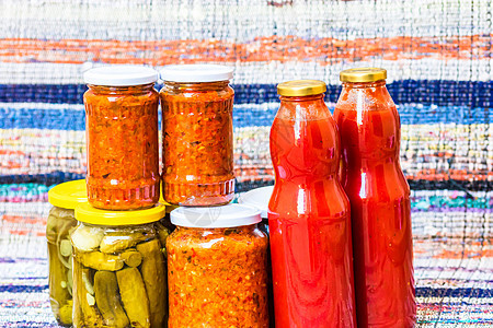 装有腌红甜椒和腌黄瓜 泡菜 的玻璃罐被隔离 装有各种泡菜的罐子 装有 zacusca 的罐子和装有番茄酱的瓶子 保存食品的概念厨图片