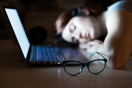 精疲力尽的雇员加班 在办公桌睡觉 晚上用笔记本电脑做最后工作 该学生正在准备考试过程压力女士商业女性学习文员桌子办公室企业家小憩图片
