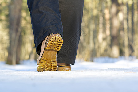 女人在冬季森林的雪上行走 专注独秀和雪活动赛跑者动机鞋类运动靴子天气男性训练工作图片