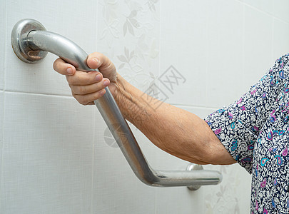 亚洲老年或老年老妇人病人在护理医院病房使用厕所浴室手柄安全 健康强大的医疗理念洗手间铁轨残障酒店金属座位苗圃汽车浴缸老年人图片
