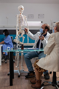 医生向领取养老金的妇女展示人体骨骼图片