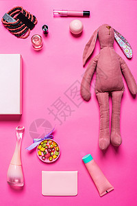 粉红背景的女孩的饰品记事本唇线魅力衣服糖果配件兔子盒子玩具管子背景图片