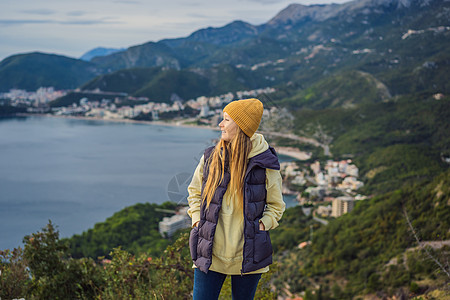 身着温暖衣服的黑山山区妇女 在春季 秋季 冬季前往黑山旅行和女性远足冒险峡湾假期天空背包女士岩石山脉图片