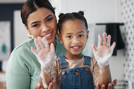 保护孩子免受疾病侵害让妈妈们放心 一名年轻女子在家里帮助女儿洗手的镜头图片