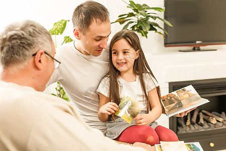 家人在客厅里看相册时父亲姐姐兴趣家庭情绪童年兄弟男孩们回忆沙发图片