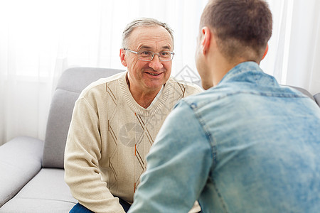 快乐的退休男人和成年儿子在家里聊天胡子男性时间长老房子杯子父母爸爸马甲成人图片