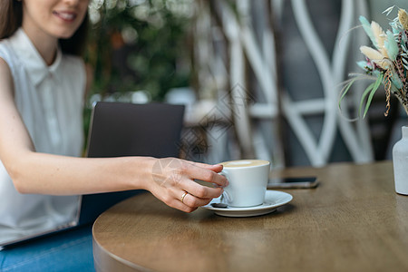 年轻女人坐在咖啡桌边喝杯咖啡 特写节目图片
