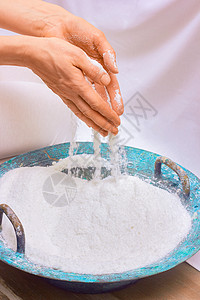 妇女的手把海水盐倒进一个蓝碗里 即皮肤护理 愈合的概念镜头男性治疗师浴盐美容和声传统特写护肤品人类图片