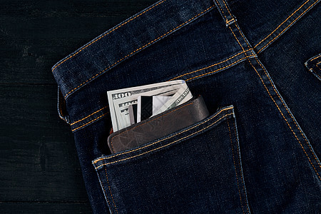 钱在蓝豆的口袋里 在木制背景和复制空间上金融贷款储蓄钱包店铺旅行账单货币卡片蓝色图片