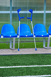 露天体育场球员的新的蓝色塑料座椅 在透明塑料屋顶下有新油漆的椅子风险长椅团队游戏足球病人公园事故情况竞赛背景图片