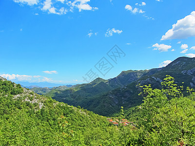 一堵山墙耸立在山谷之上 在阳光明媚的日子里 温暖的色调与山上的一个小村庄 山岩花岗岩丘陵冒险天空国家首脑假期牧场森林旅游山脉图片