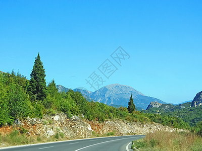 通往大山的道路 通往山路 左转 您可以看到侧面的标记和植被 夏日背景中的山图片