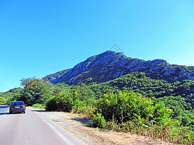 一条路 有一辆汽车和山地背景的山脉 夏天在意大利 奥加马卡拉(Onga mcala)与绿树一起长大图片