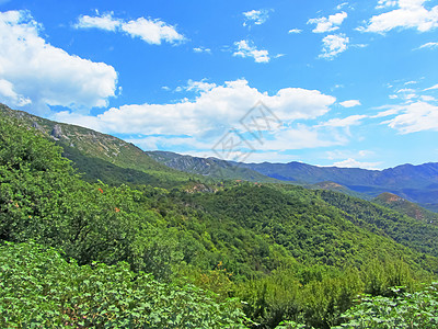 一堵山墙耸立在山谷之上 在阳光明媚的日子里 温暖的色调与山上的一个小村庄 山岩花岗岩爬坡山脉森林顶峰旅行日出牧场假期首脑公园图片