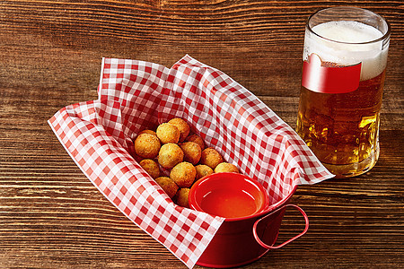 热奶酪球 加酱汁和啤酒杯 在木制桌上起动机油炸酒吧食物玻璃餐厅海鲜胡椒辣椒面包屑图片