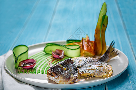 以黄瓜和洋葱为装饰的炸鱼多拉多饮食海鲜沙拉木头盘子烹饪美食油炸午餐食物图片