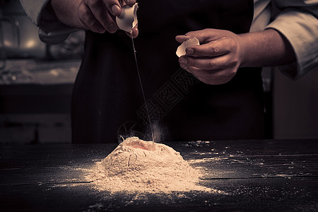 厨师把鸡蛋碎成木桌上的面粉桌子烹饪烘烤手工糕点面包营养木板食谱工作图片