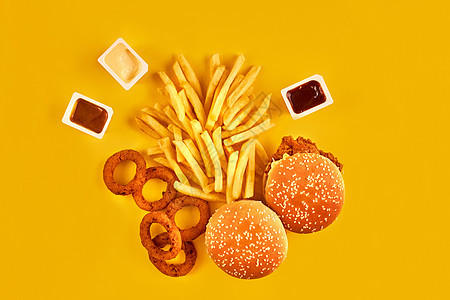 快餐和不健康的饮食概念  黄色背景中快餐小吃的特写土豆油炸零食垃圾广告生活化合物乌贼烹饪育肥图片