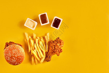 薯条 汉堡包 蛋黄酱和番茄酱 在黄色背景上 笑声食谱楔子生活营养包子土豆作品沙拉蔬菜筹码图片